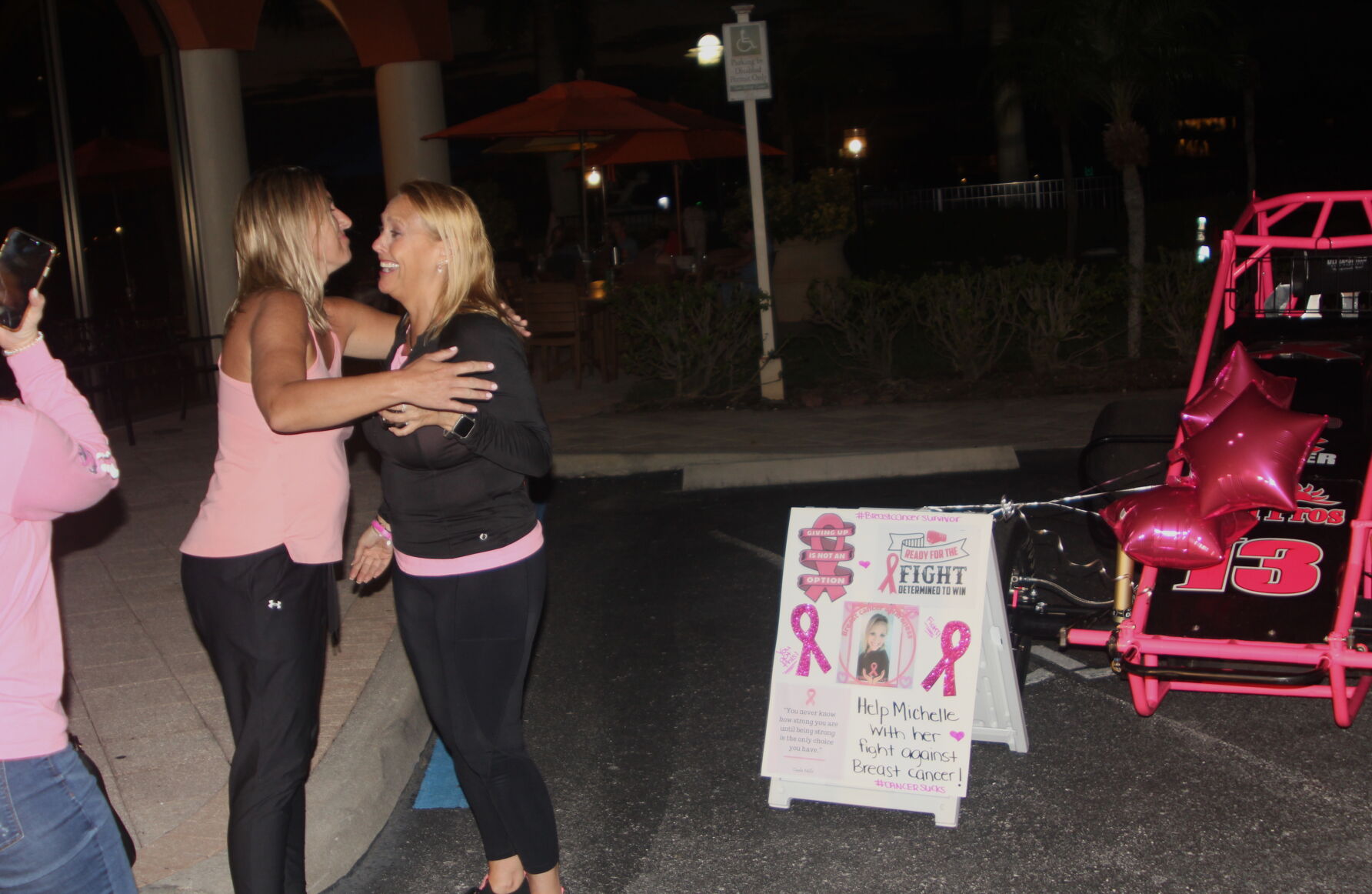 Woman Fights 2. Danielle Webb, left, connects with Michelle Thurston at the fundraiser that featured a signature pink sprint car..jpg